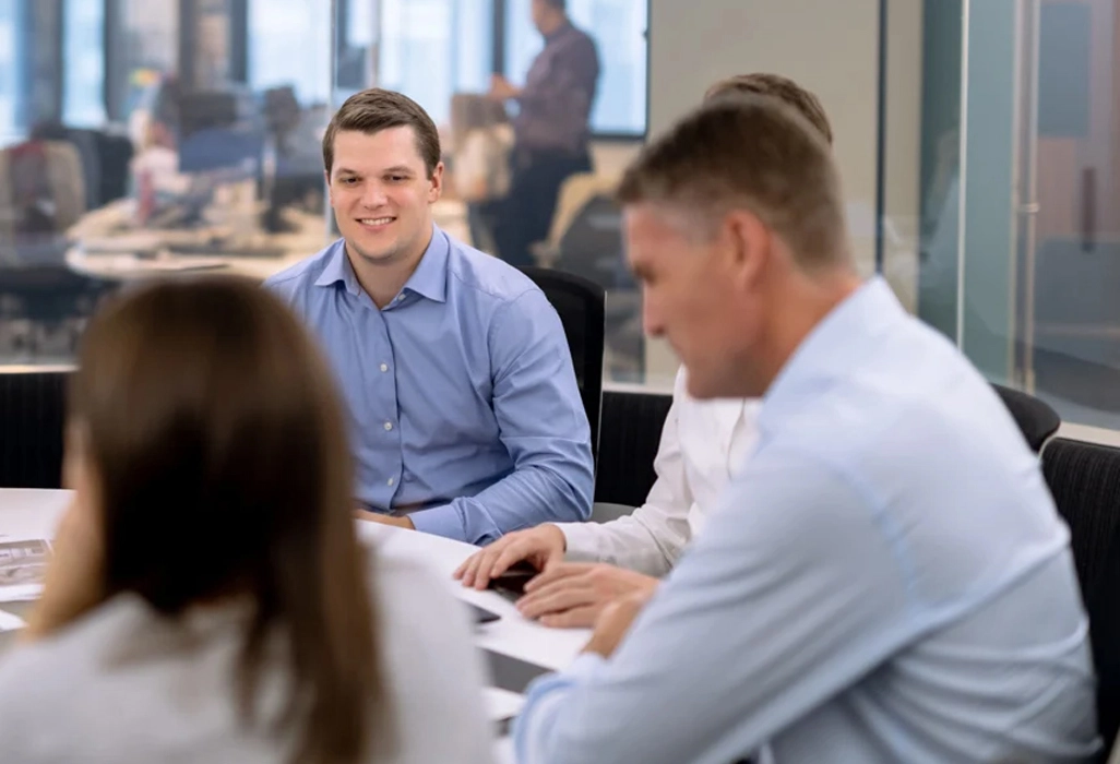 A professional group of people in an office meeting setting, representing the collaborative use of psychometric assessments to enhance team performance and leadership potential.