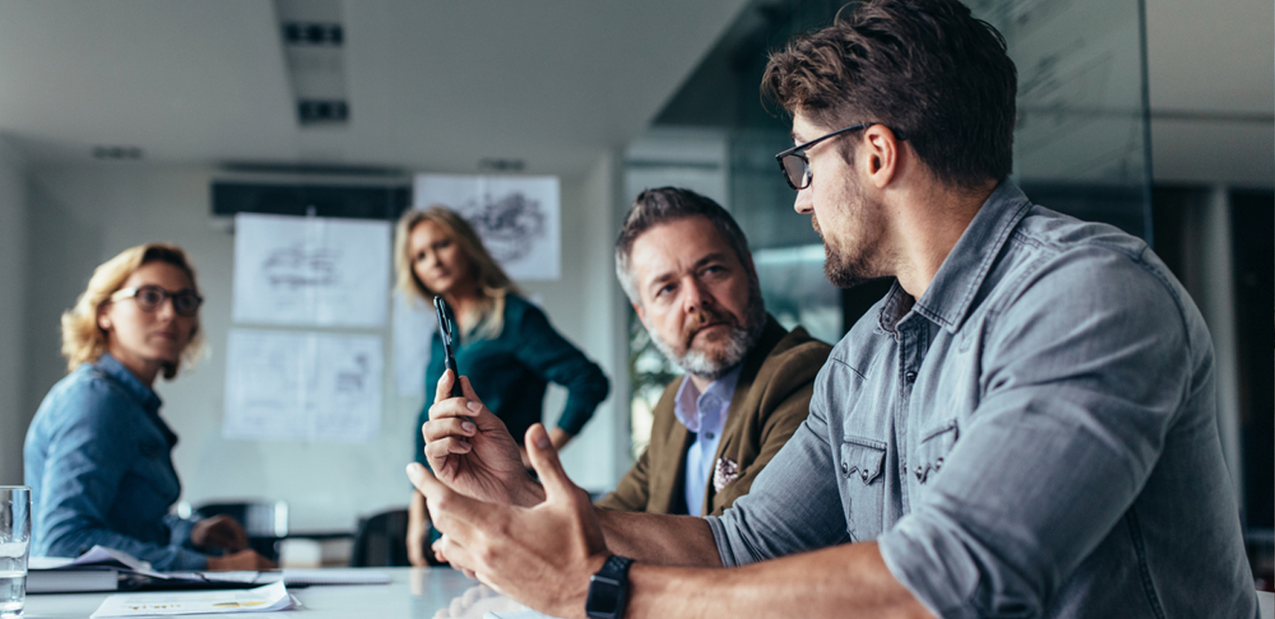 A professional group of managers and executives in a focused boardroom discussion, representing the collaborative and strategic nature of Get Mentally Fit's high-impact leadership coaching.